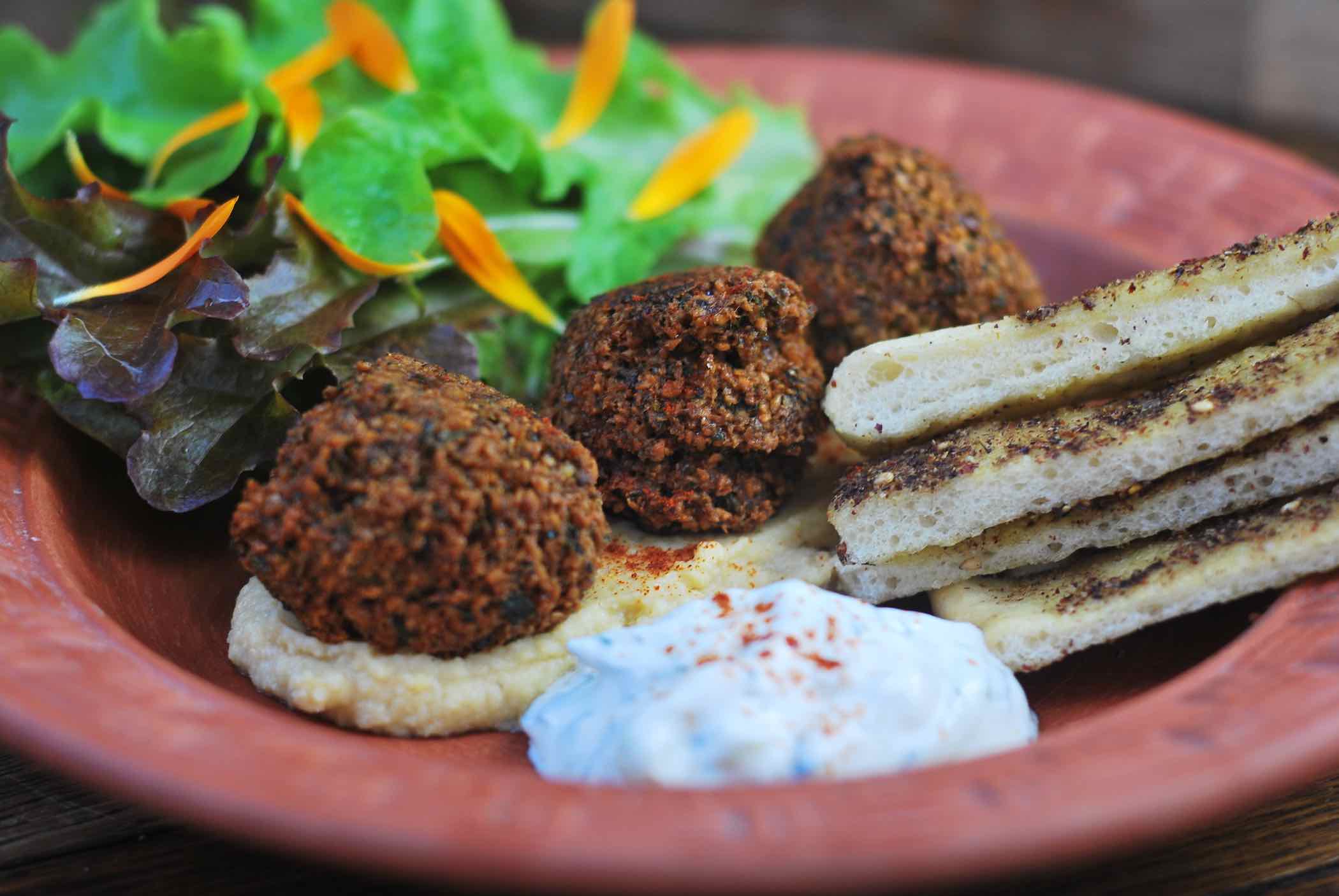 Falafels on a plate with flatbread, salad and houmus