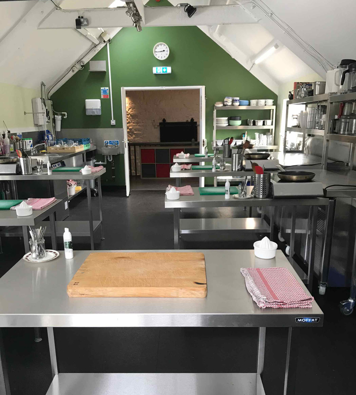 Natural Cookery School kitchen view from Erin's work station, with socially-distanced work spaces